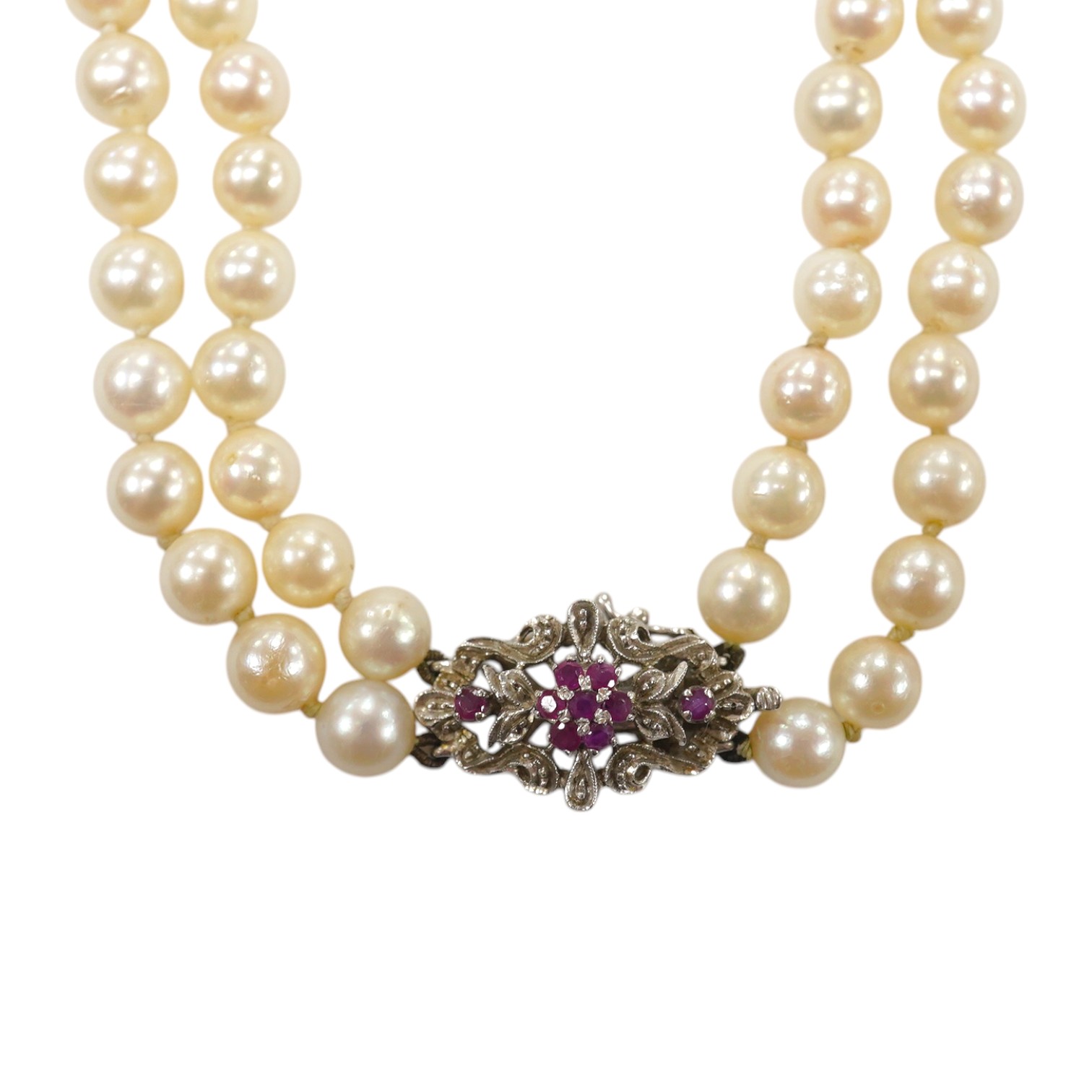 A modern double strand cultured pearl necklace, with ruby cluster set 750 white metal clasp. Condition - poor to fair